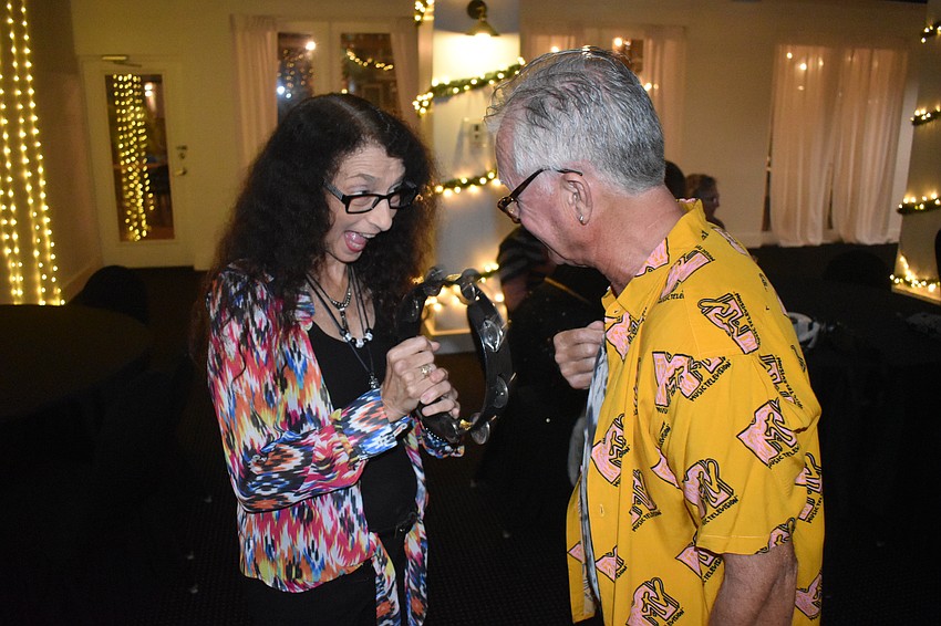 Sue Goldstein receives a tambourine from Steven Mark.