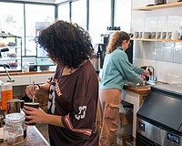 Barista Claudia Aridus pours a latte while Sara Rountree rinses a cup at Sips this January. The popular north-end coffee shop is expanding with a second location on Longboat Key.