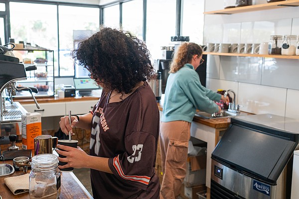 Barista Claudia Aridus pours a latte while Sara Rountree rinses a cup at Sips this January. The popular north-end coffee shop is expanding with a second location on Longboat Key.
