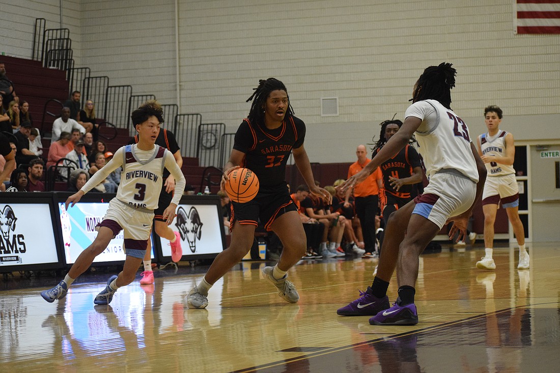 Senior forward David Young (33) dribbles up the court with two defenders on him during a Jan. 9 game between Sarasota and Riverview. The Sailors have leaned on Young, among others, with Johnny Lackaff unavailable.