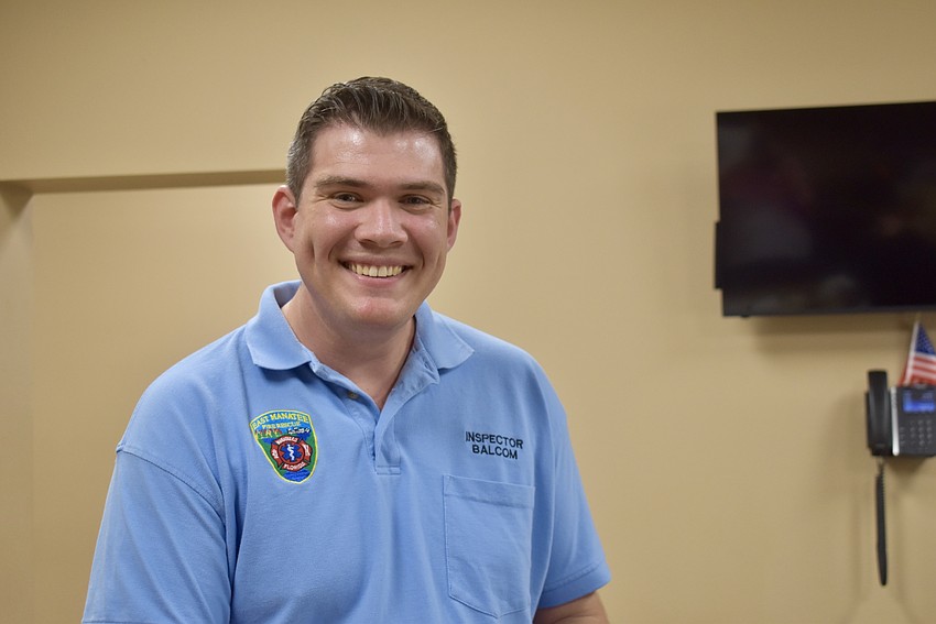 Inspector Tyler Balcom stops in the kitchen to grab a plate.