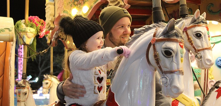 Bradenton's Harley Busch, 3, is eager to ride the carousel alongside her father John Busch at the Manatee County Fair. She also rode a camel moments before.