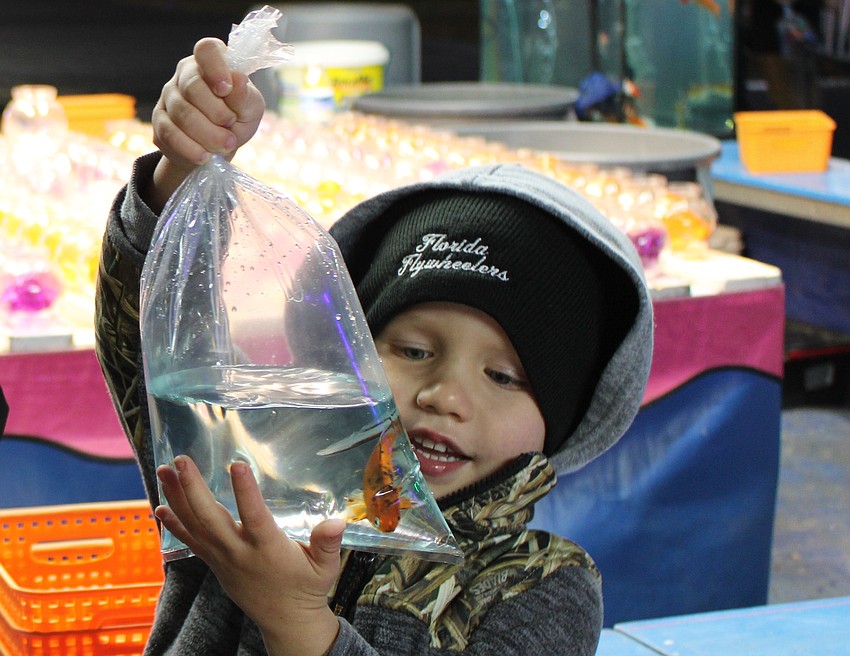 Myakka City's MJ Leworthy takes a look at the fish he won at the Manatee County Fair.