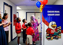 Bonnie Michaels, literacy coach at Alta Vista Elementary School, helps students Deja (5th grade), Gianni (4th grade), Yoselyn (1st grade) and Andre (2nd grade) try out the new book vending machine. Sarasota Yacht Club youth board members coordinated the installation to help promote strong reading habits.