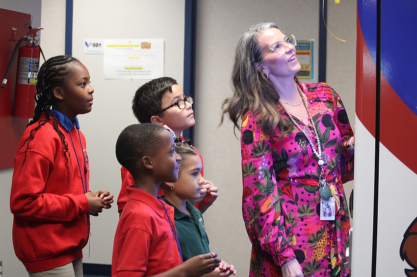 Alta Vista Elementary School students Deja (5th grade), Gianni (4th grade), Yoselyn (1st grade) and Andre (2nd grade) eagerly examined the book selection in the new vending machine with literacy coach Bonnie Michaels.