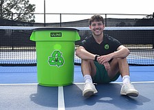 Dillon Rosenthal, a fourth-year entrepreneurship major at FGCU, proudly sits beside one of BounceBack Pickle's bins. His business takes old, broken pickleballs and recycles them into new ones.