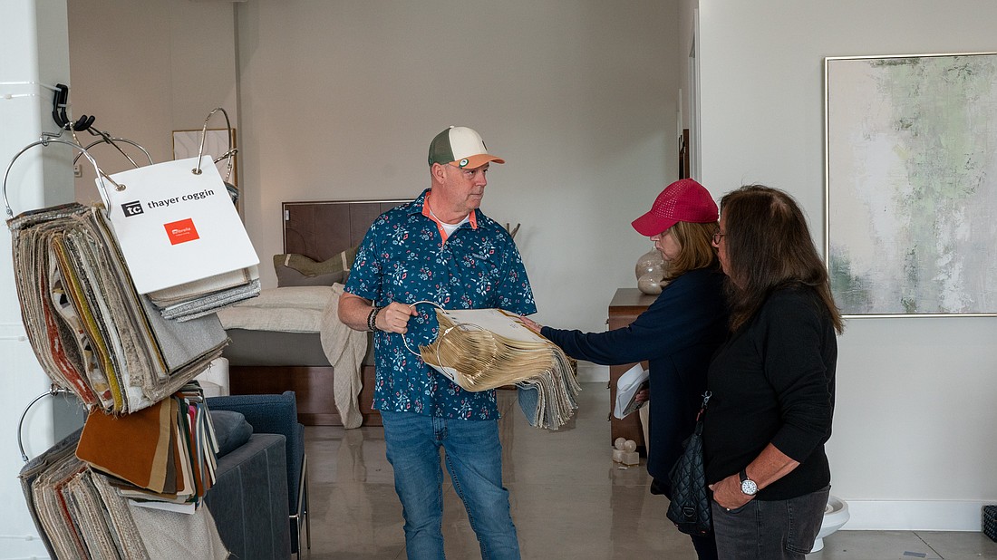 Couch LBK co-owner Ken Rushing shows a pair of shoppers a fabric sample inside the furniture showroom at Brista Commons Wednesday, Jan. 14.