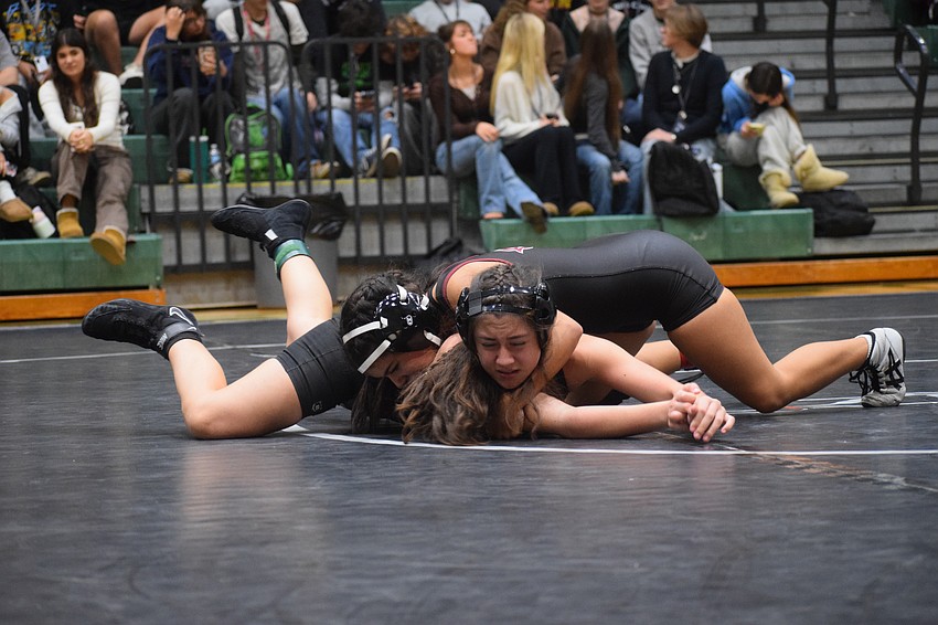 Freshman Bailey Loring of Lakewood Ranch (bottom) goes toe-to-toe with Maria Chaffardett (top) in the 110-pound weight class.
