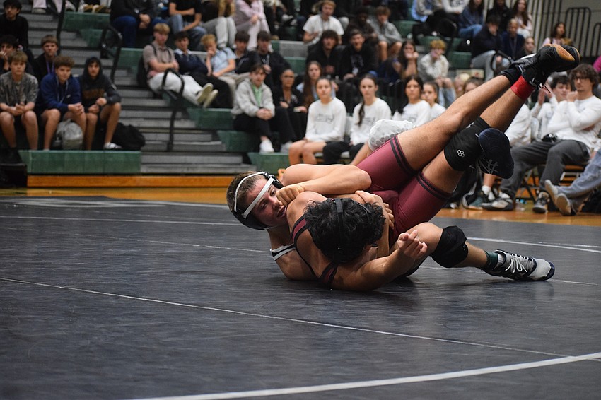 Senior Heath Phillips of Lakewood Ranch tussles with Cesar Cisneros in the 144-pound weight class.