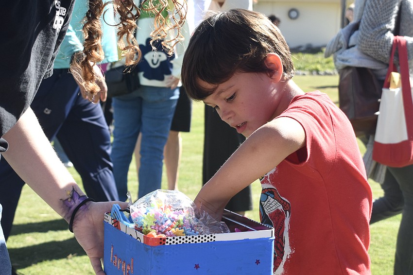 Alex Benedek, 5, draws a prize after fishing for rubber ducks.