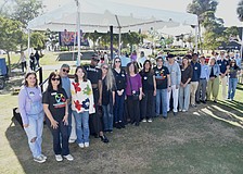 Artists from Embracing Our Differences line up to be recognized alongside President and CEO Sarah Wertheimer (right).