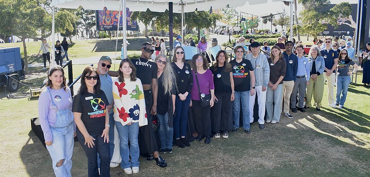 Artists from Embracing Our Differences line up to be recognized alongside President and CEO Sarah Wertheimer (right).