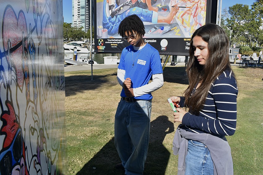 Jaden Stotz, 16, and Annie Rex, 16, work on a piece of community artwork.
