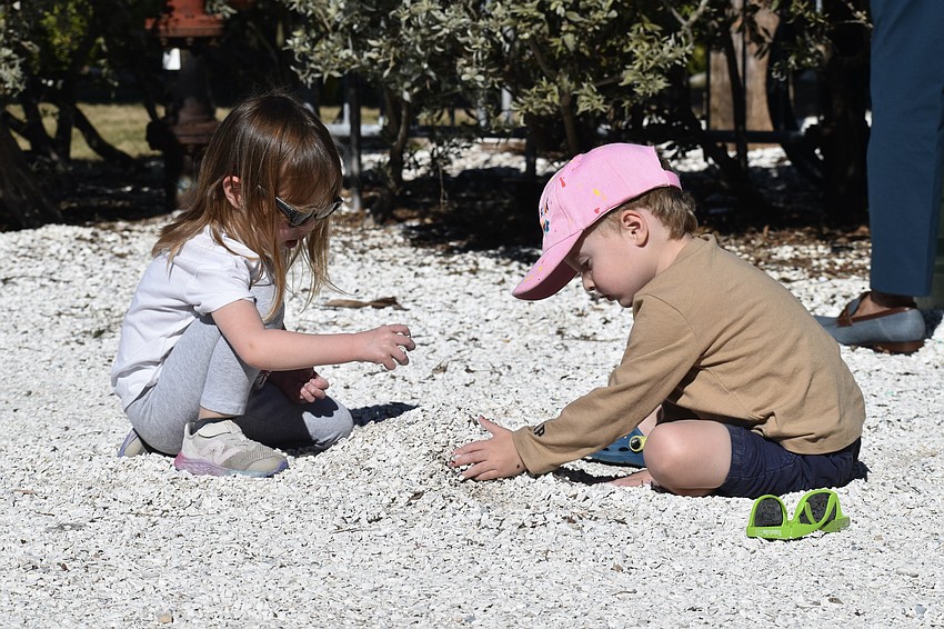 Norah Alexander, 3, and Avery Applefield, 3, play with the rocks on the park ground.