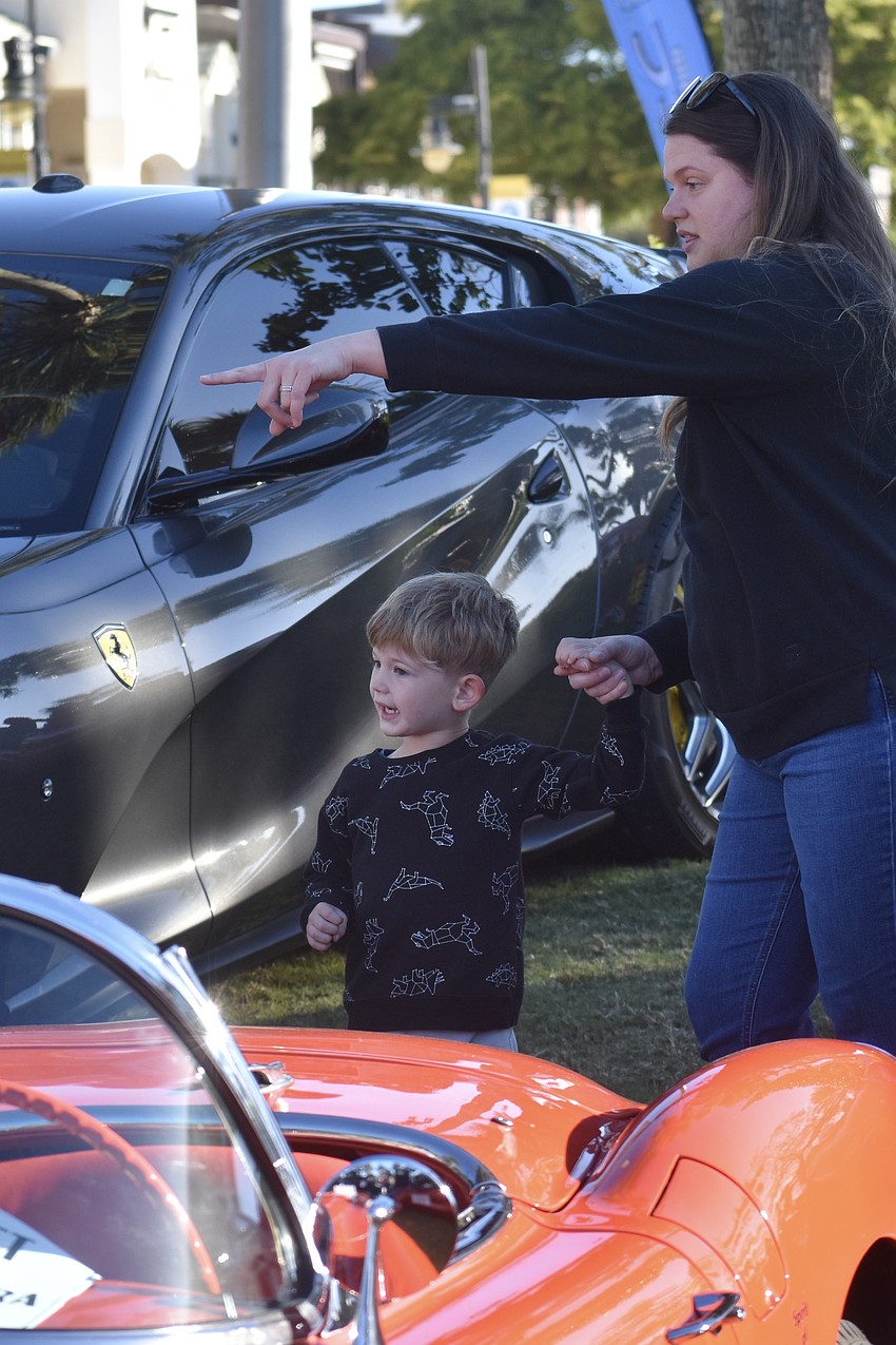 Colton Thomas, 3, and Taryn Thomas explore the cars.