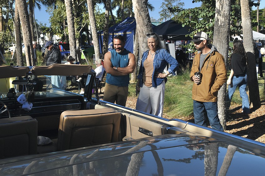 Scott Melton and Chloe Lee look at a 1964 Lincoln Continental Convertible owned by Phil Annunziato and being showcased by automotive restoration specialist Chris Hartner.