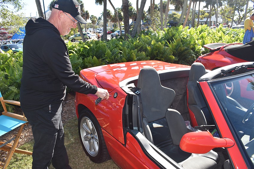 Charles Lenher demonstrates the door, which descends into the side of the vehicle, on a 1990 BMW Z1. He helped his friend Jurgen Otto to drive the car there.