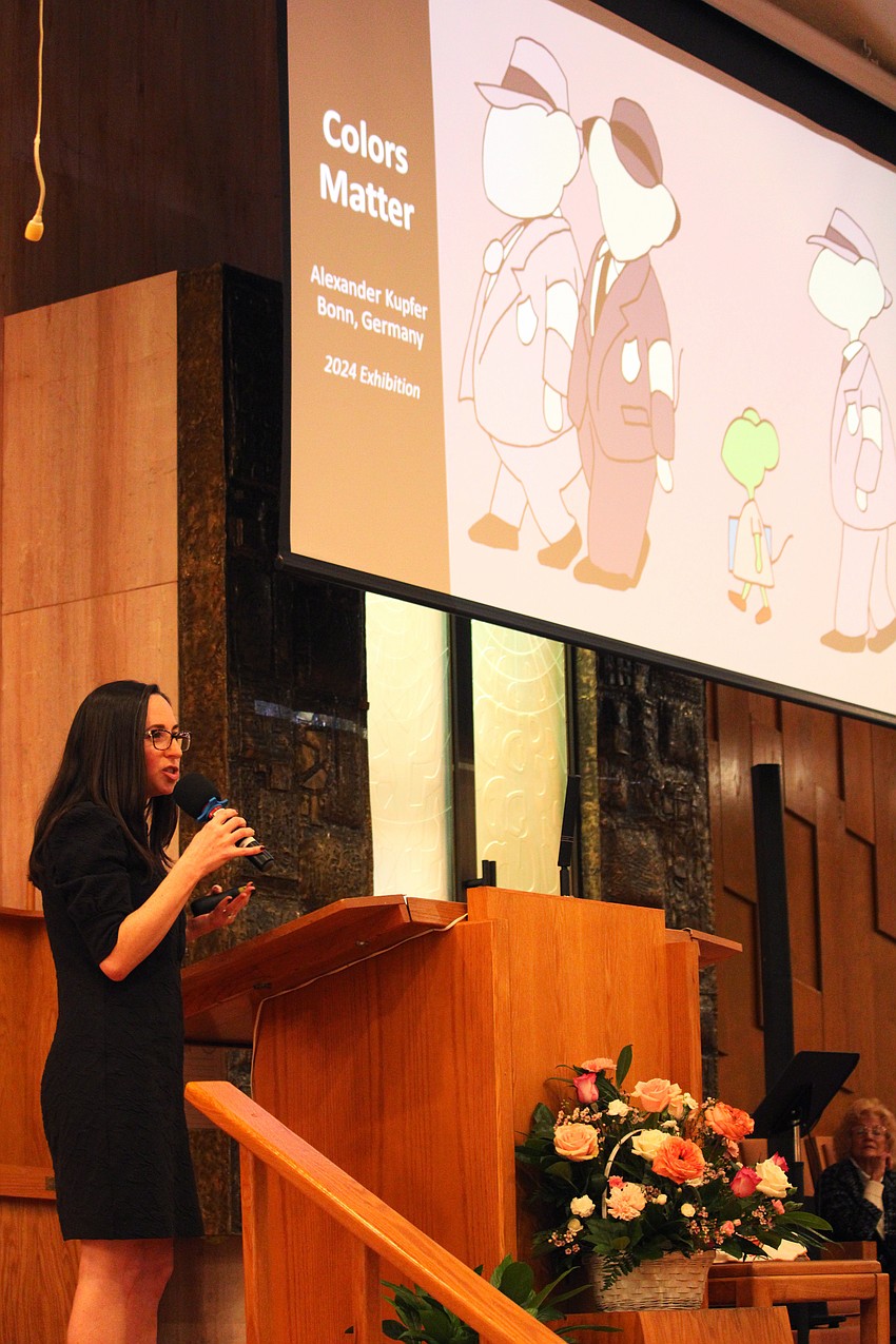 Sarah Wertheimer, president and CEO of Embracing Our Differences, explains her team's motivation to hold a free, public art showcase that does not censor artists' work. Her, she shows a piece by artist Alexander Kupfer from Bonn, Germany, titled 