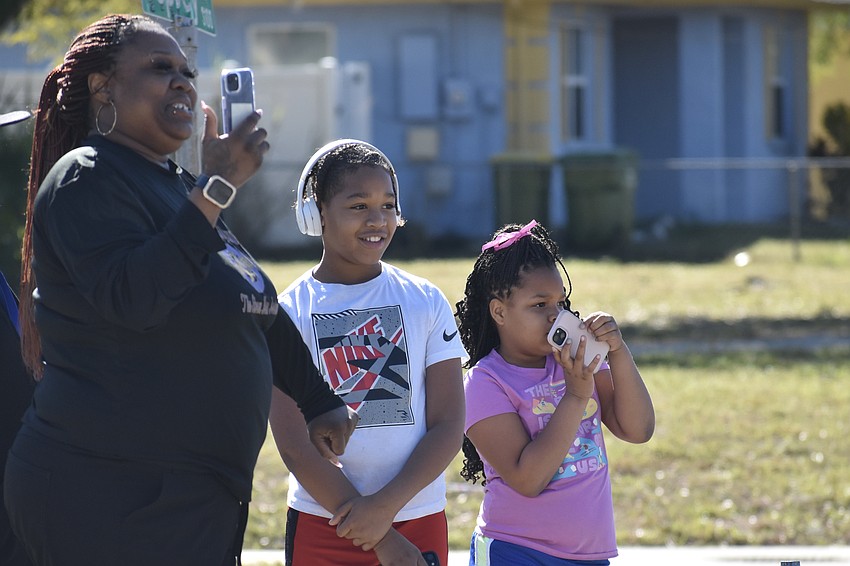 Sharon Sorey and her kids Clarence Johnson, 8, and Claire Johnson, 7, watch the parade. Sorey's daughter Markajah Jackson is in Booker High School's JROTC program.