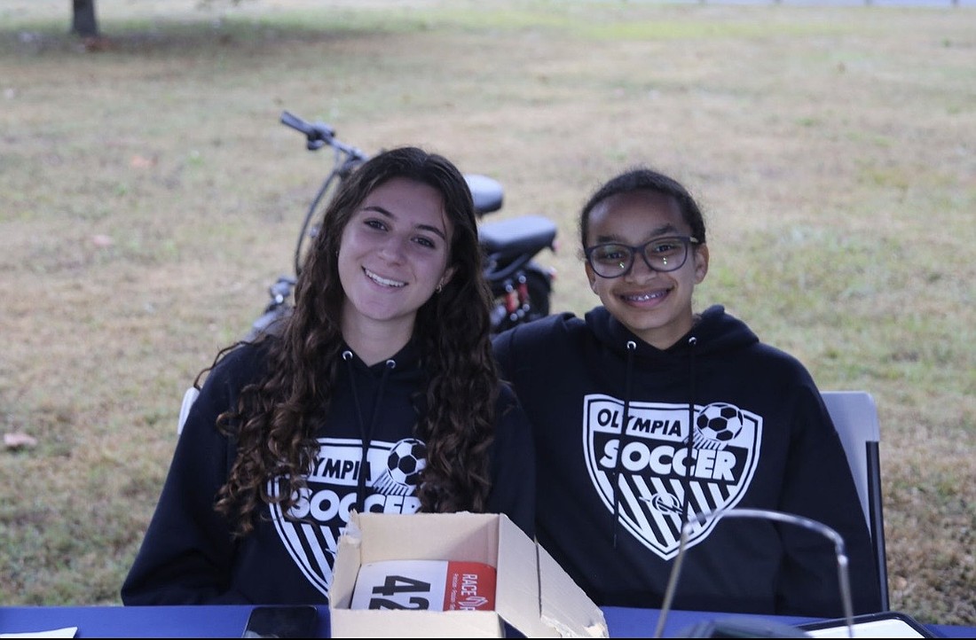Olympia girls soccer players Dunia Abu Soud and Racquel Monestime tended the check-in booth during last year’s Titan Trot.