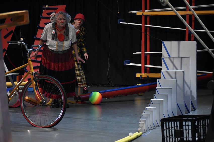 Educational Outreach Manager Karen Bell and Kepler Henry watch as a small ball accelerates towards its target.