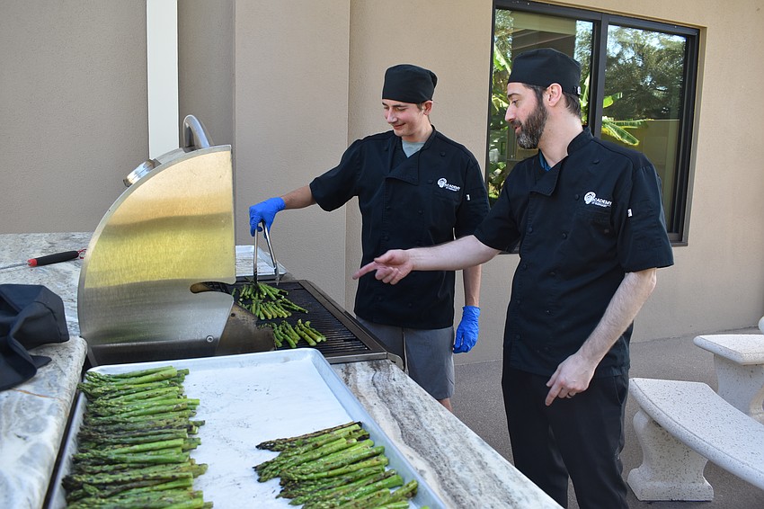 Patrick Callahan grills asparagus with advice from Chef Instructor Benjamin Burnside.
