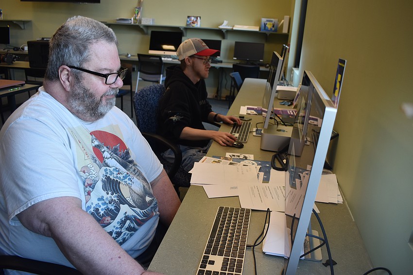 John Peacock and Jake Whitmer work on content for the organization.