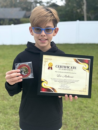 Lev Makarov with a medal and Certificate of Achievement for passing the Algebra 1 and Geometry end of course exams with a Level 5 achievement, the state's highest achievement level. Courtesy photo