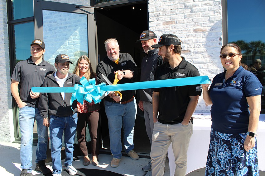 Peter Beale, owner of Your Flooring Warehouse, cuts the ribbon for the business' grand opening with his team and representatives from the Longboat Key Chamber of Commerce.