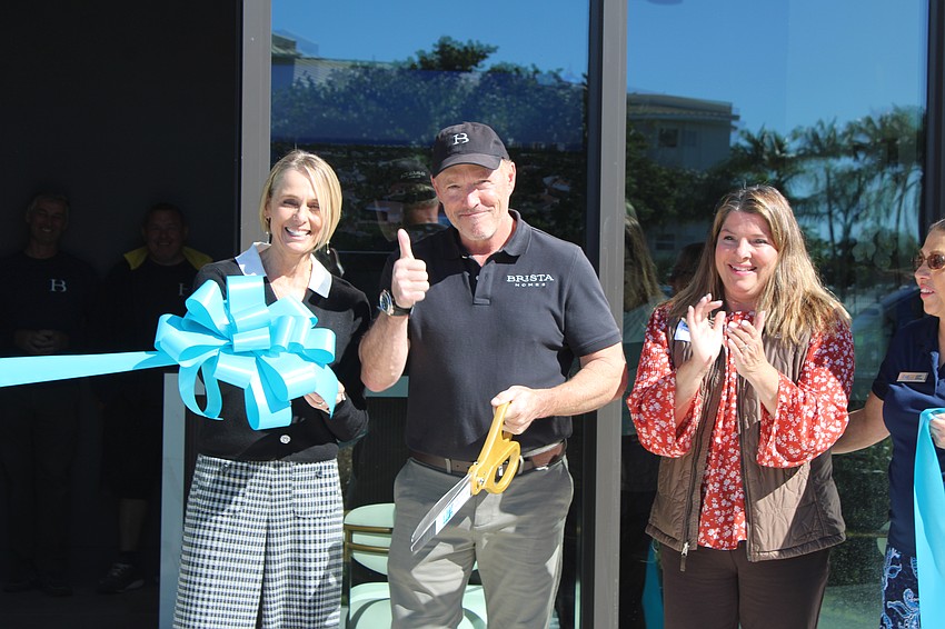Brista Homes owner Mark Ursini gives the thumbs up as he and Brista Realty owner and broker Gina Ursini cut the ribbon on opening day on Jan. 20 with Longboat Key Chamber of Commerce President and CEO Kim Verreault.