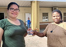 A registrant receives a gift card from volunteer Moana Dooley (right).