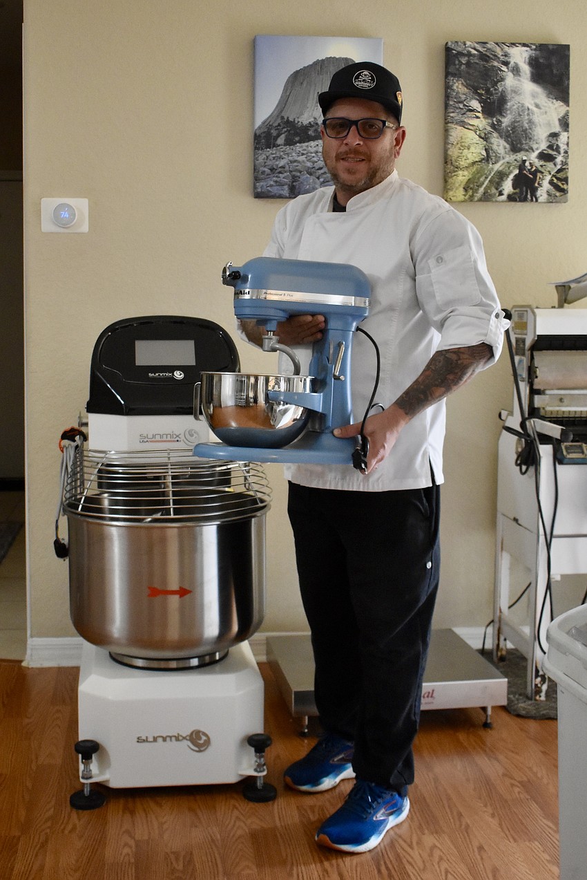 Adam Shimer started making sourdough in the KitchenAid stand mixer he's holding. He's since upgraded to a much larger mixer.