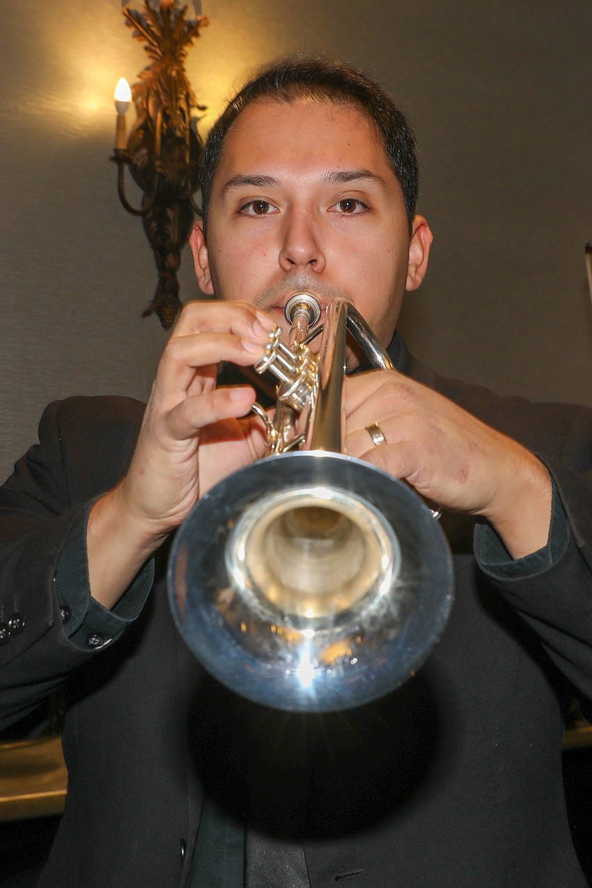 Austin Cruz tunes up his trumpet.