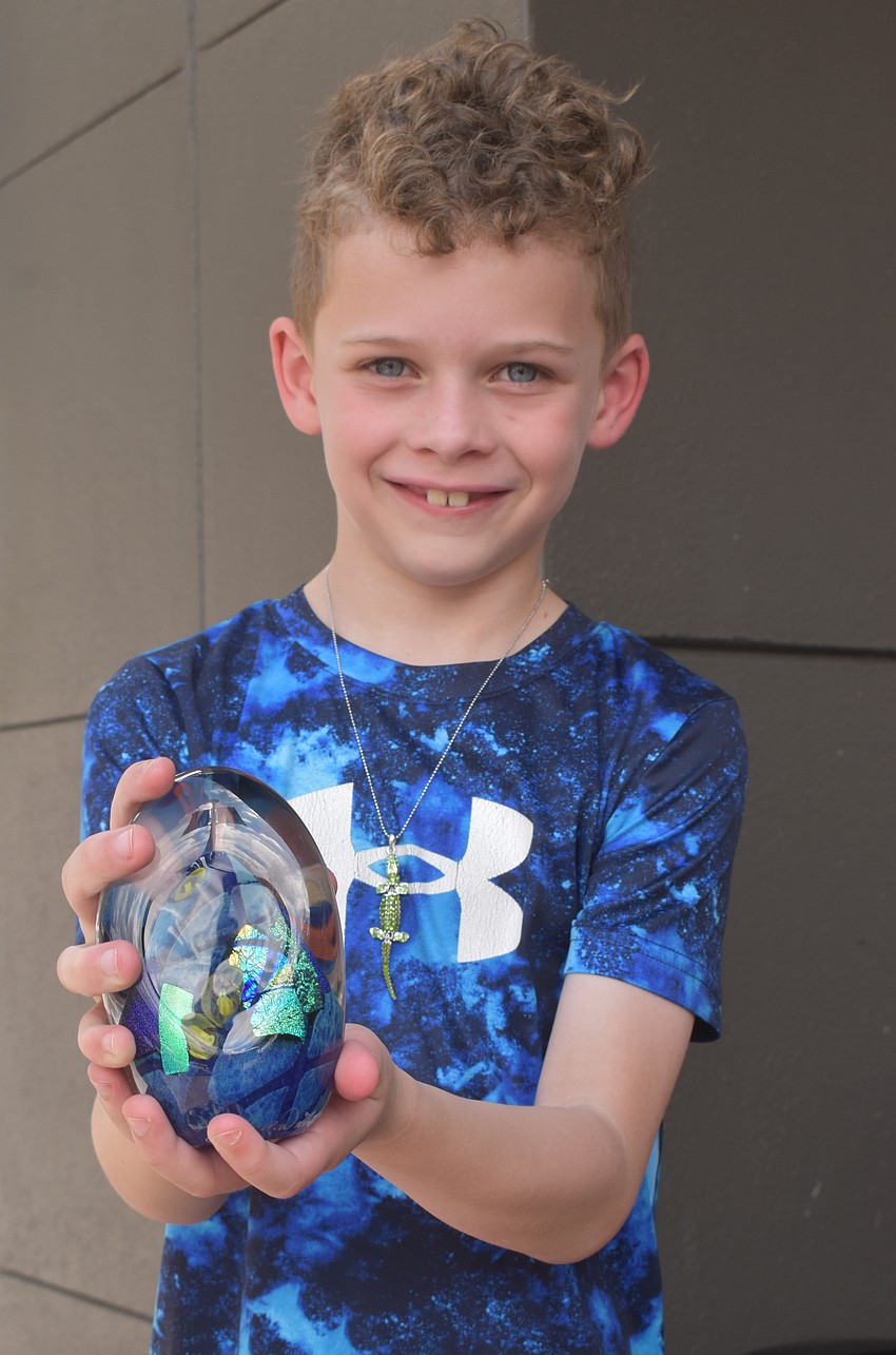 Boston's Callum Chisholm, 7, is excited to put his new glass paperweight on his desk. It was made by James Wilbat of James Wilbat Glass.