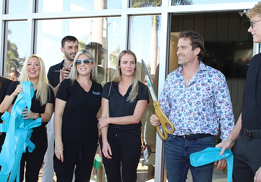 Reed Medical Group and Longboat Key Fitness both celebrated their grand reopenings on Jan. 22 at the Shoppes of Bay Isles complex, introducing visitors to their expanded facilities. Dr. James Reed, owner of the concierge medical service, wields the big scissors.