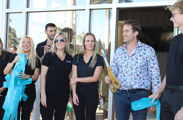 Reed Medical Group and Longboat Key Fitness both celebrated their grand reopenings on Jan. 22 at the Shoppes of Bay Isles complex, introducing visitors to their expanded facilities. Dr. James Reed, owner of the concierge medical service, wields the big scissors.