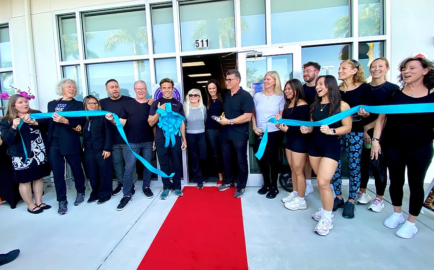 Staff members and friends give a cheer at the ribbon-cutting ceremony for Longboat Key Fitness.