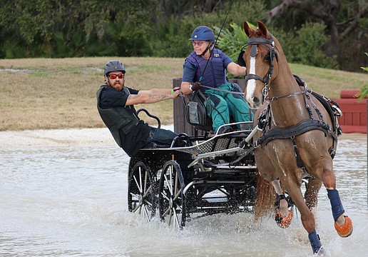Navigator Gary Yeager balances the cart as driver Kami Landy goes into a turn during the Combined Driving at TerraNova marathon event Jan. 24.