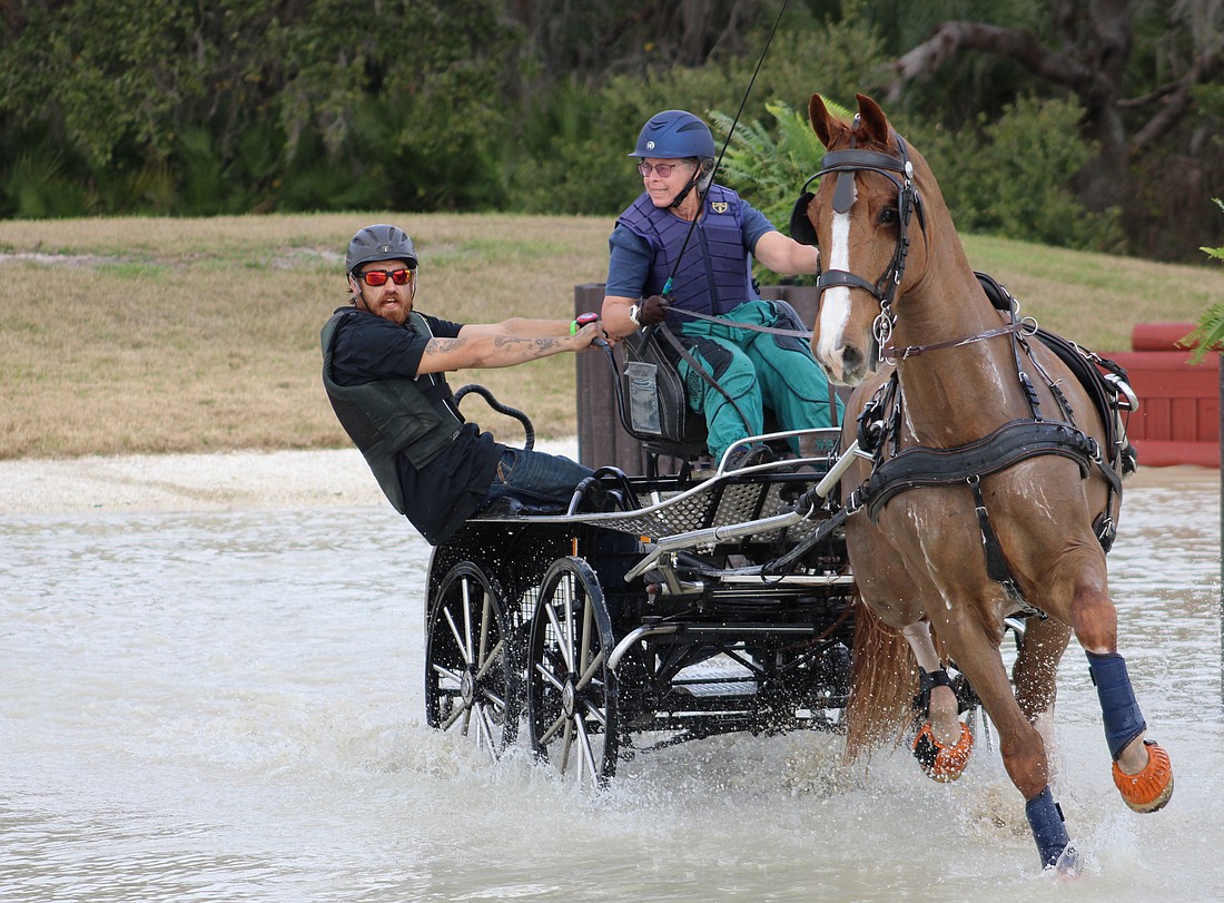 Navigator Gary Yeager balances the cart as driver Kami Landy goes into a turn during the Combined Driving at TerraNova marathon event Jan. 24.