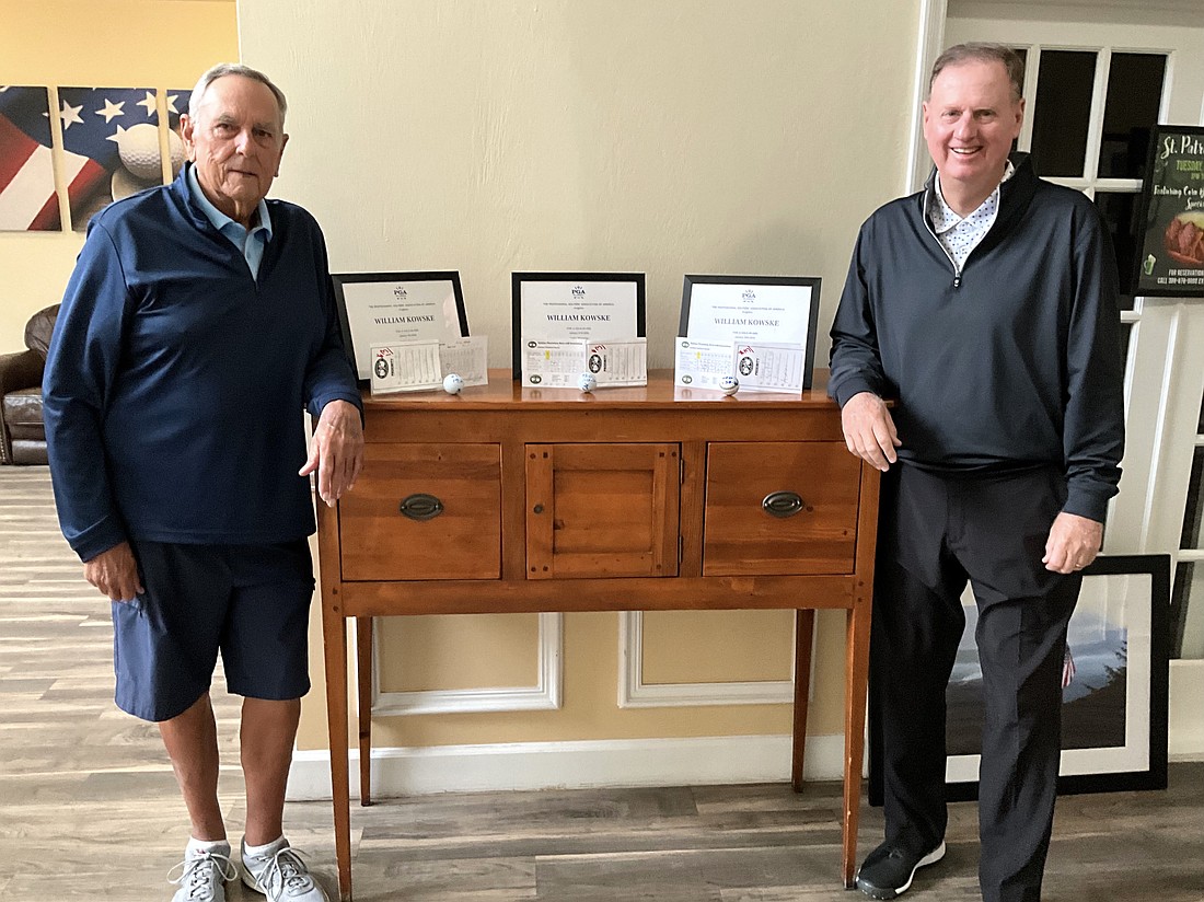 Bill Koske (left) and Halfax Plantation golf pro Bobby McCrimmon pose with Koske's three-framed hole-in-one certificates as well as the scorecards and balls Koske used for each ace. Courtesy photo