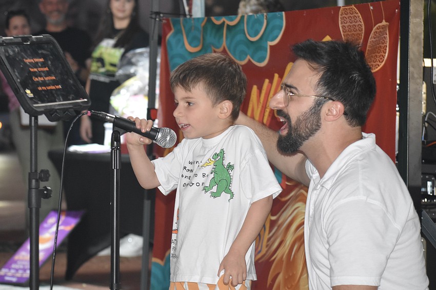 Sandro Mangione, 4, and his father, Mike Mangione, take to the microphone to sing karaoke.