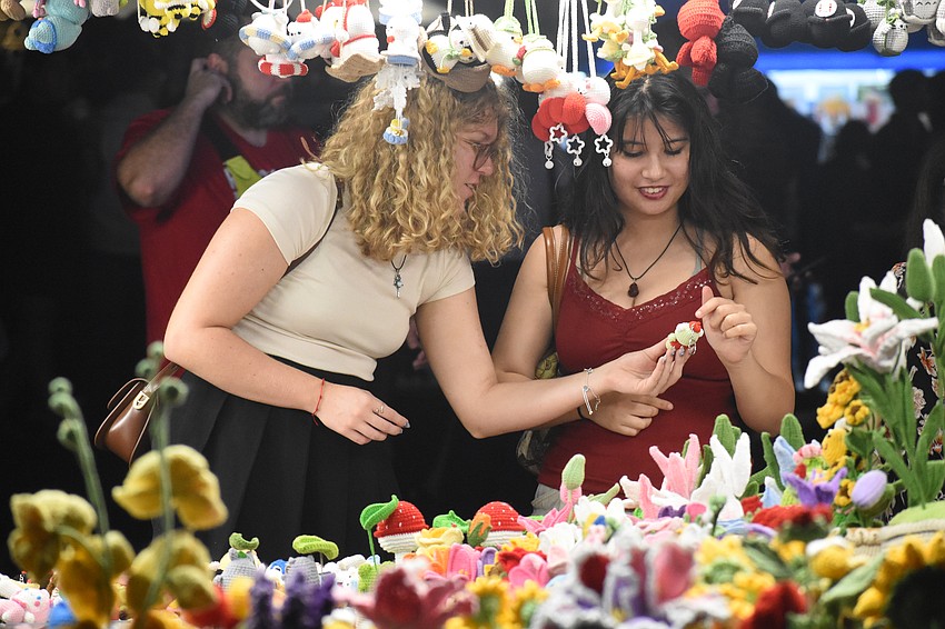 Liz Khodzhaieva and Aeon Johnson explore the crochet items.