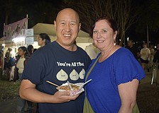 Jay Poon holds a container of takoyaki, with his wife, Sadie Poon.