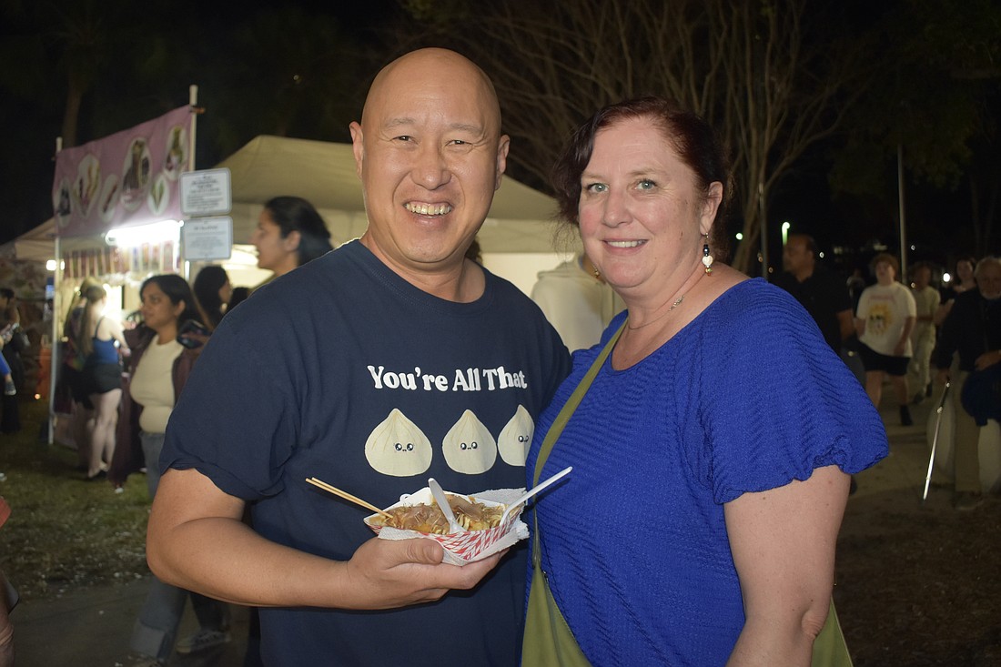 Jay Poon holds a container of takoyaki, with his wife, Sadie Poon.