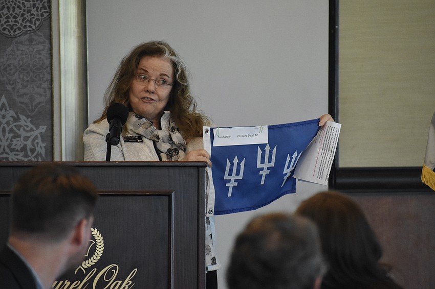 Past Lieutenant Commander Sylvia Wedge initiates the ceremony involving the passing of the flag.