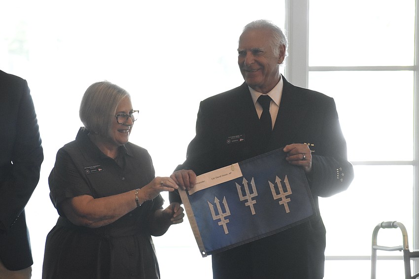 Immediate Past Commander Barbara Warshaw passes the flag to Commander David Siesel.
