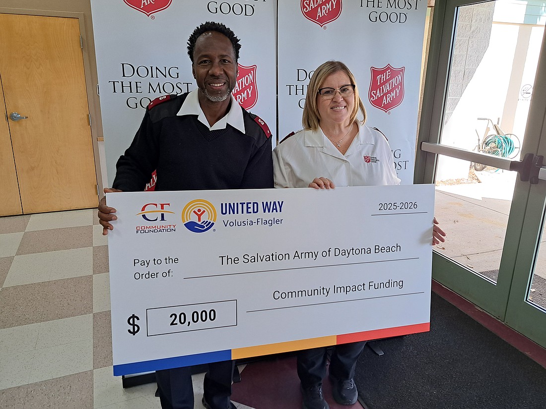 Lt. Tim Green and Lt. Kalynn Green, Corps Officers with The Salvation Army’s Daytona Beach Corps, pose with a $20,000 check supporting expanded services for students in The Beacon of Hope after school program. Courtesy photo