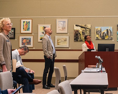 Christ Church pastor Julia Piermont (standing, left) attended a Lonbgoat Key Planning Board quasi-judicial hearing where the board approved the redevelopment of a neighboring lot into 58 parking spaces.