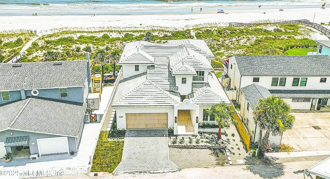 Oceanfront two-story home features four bedrooms, four full and one half-bathrooms, porches, balcony and patio.