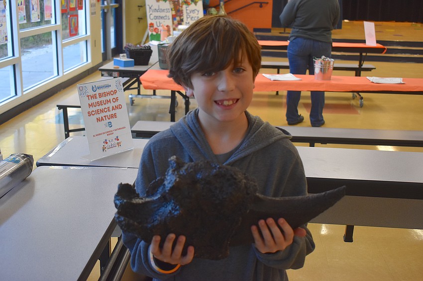 Kaleb Barcomb, a fourth grade student at Myakka City Elementary, holds a giant ground sloth claw model from the Bishop Museum of Science and Nature.